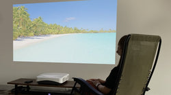 プロジェクターでリゾート地の海の映像を観ているFunLogyのスタッフ