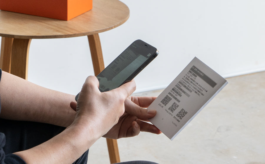 FUNLOGYの取扱説明書QRを、スマホで読み取る男性の手。